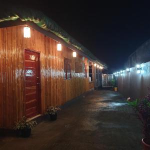 a row of wooden buildings at night with lights at Beachhouse for 15 pax with pavilion in Nasugbu