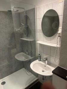 a bathroom with a shower and a sink and a mirror at Appartement Rathausplatz in Kempten +16 photos