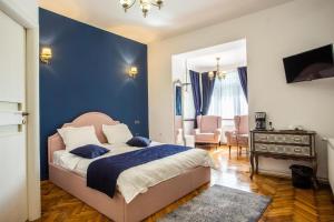 a bedroom with a bed and a blue wall at Margarethengasse Comfort Rooms Old Town in Sibiu