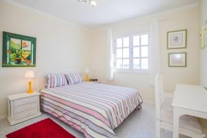 a white bedroom with a bed and a window at Villa Tabaiba in Haría