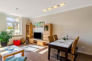 a living room with a dining room table and a television at Fewo Theo im Ferienhaus Alte Schule in Ferna
