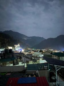 a view of a city at night with mountains at Spiritual Oasis in Rishīkesh