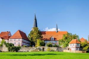 a large building with red roofs in a green field at Fewo Theo im Ferienhaus Alte Schule in Ferna