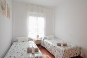 a bedroom with two beds and a window at El Rincón Sevillano in Gerena
