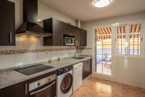 a kitchen with a sink and a washing machine at El Rincón Sevillano in Gerena