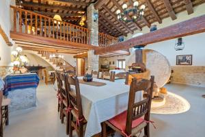 a large dining room with a table and wooden ceilings at Lo Molí de la Jòrdia in Tortosa