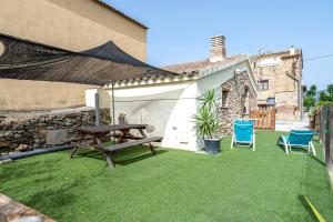 a patio with a picnic table and two chairs at Lo Molí de la Jòrdia in Tortosa