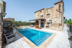 a swimming pool in front of a stone building at Lo Molí de la Jòrdia in Tortosa