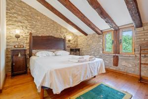 a bedroom with a bed and a stone wall at Lo Molí de la Jòrdia in Tortosa +29 photos