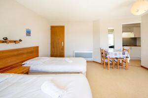 a hotel room with two beds and a table at Les Mimosas - Appartement 07 in Cazaubon