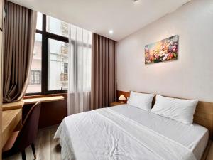 a bedroom with a bed and a desk and a window at Aurora Homestay in Hanoi