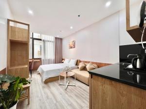 a kitchen and a living room with a bed and a couch at Aurora Homestay in Hanoi