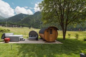 a round tent and furniture in a field with a tree at Apartments Hofmann in Prateria