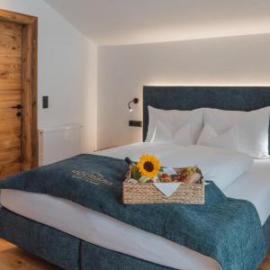 a bed with a basket with a sunflower on it at Apartments Hofmann in Prateria