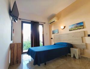 a bedroom with a blue bed and a large window at Hostal Horizonte in San Antonio