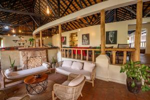 a living room with a couch and chairs and a table at Sambiya River Lodge in Murchison Falls National Park