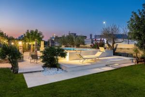 a patio with two chairs and a pool at night at Masseria De Donno in Specchia