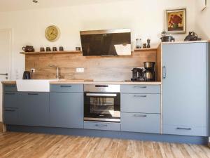 a kitchen with blue cabinets and a white refrigerator at Ferienwohnung Im Weiler, 70 Qm in Winterlingen +19 photos