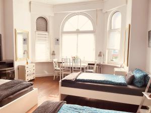 a bedroom with two beds and a table and chairs at Pension Nazli Elmshorn in Elmshorn
