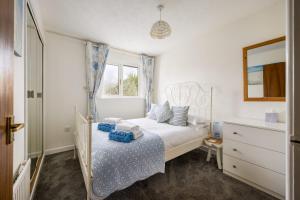 a white bedroom with a bed and a window at Dolphin Cottage - Short walk to Poole Quay with Private Garden in Poole