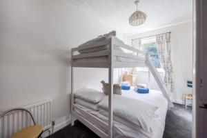 a white bunk bed in a room with a window at Dolphin Cottage - Short walk to Poole Quay with Private Garden in Poole