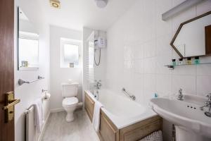 a white bathroom with a toilet and a sink at Dolphin Cottage - Short walk to Poole Quay with Private Garden in Poole +27 photos