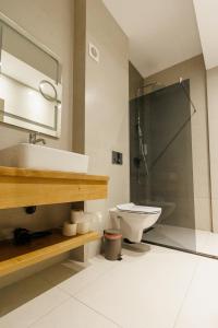 a bathroom with a sink and a toilet and a shower at Confort Apartment in Iaşi