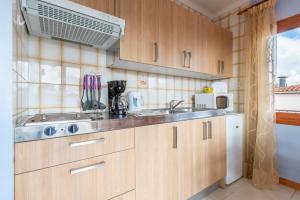a kitchen with wooden cabinets and a sink at Apartamento Portosun Estrella in Portocolom