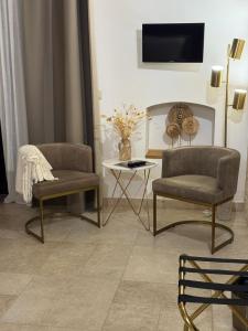 a living room with two chairs and a table at Dimora Caraspi in Mola di Bari