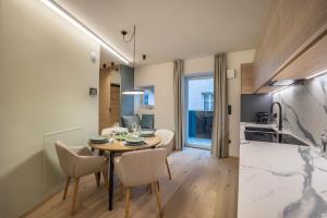 a kitchen and dining room with a table and chairs at Avia Living Teresa in Brunico