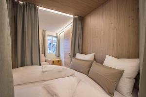 a bedroom with a large bed with white pillows at Avia Living Teresa in Brunico