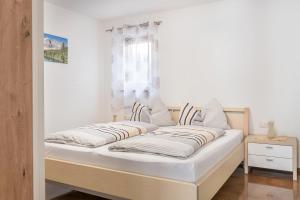 a bed in a room with white walls at Trojer Apartment 1 in Sarntal