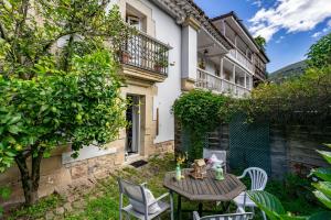 a patio with a table and chairs in front of a building at Apartamento 4 Casa Las Indianas in Selores