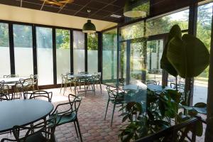 a dining room with tables and chairs and a plant at Maison Bourgeoise de caractère in Tarare