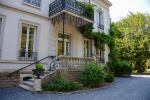 a white house with a balcony and stairs at Maison Bourgeoise de caractère in Tarare
