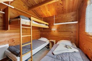 two bunk beds in a cabin with wooden walls at Chalet confort 12 in Saint-Gervais