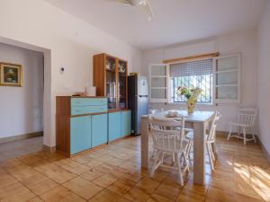 a kitchen with a table and a blue refrigerator at Villa Assunta in Lecce +16 photos