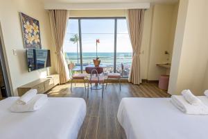 a hotel room with two beds and a view of the ocean at Cham Charm Home Mui Ne in Ấp Thiện Phước +153 photos
