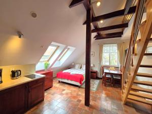 a bedroom with a bed and a kitchen with a desk at Chata Rybacka Saule in Ustka