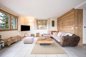 a living room with a couch and a table at Chalet Coeur de Savoie in Cléry