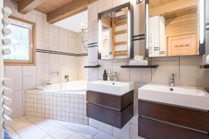 a bathroom with two sinks and a tub at Chalet Coeur de Savoie in Cléry +29 photos