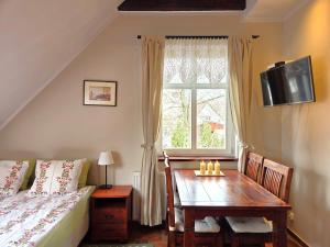 a bedroom with a bed and a table and a window at Chata Rybacka Saule in Ustka