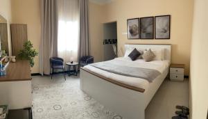 a bedroom with a large white bed in a room at رخاء للغرف الفندقية in Firq