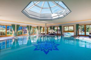 an indoor swimming pool with a glass ceiling at Hotel Singer – Relais & Châteaux in Berwang