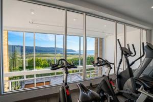 a gym with two exercise bikes in front of a large window at 408 - Modern Condo - Pool & Panoramic View in Baie-Saint-Paul