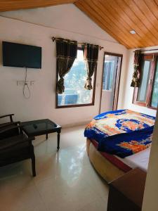 a bedroom with a bed and a flat screen tv at The Plaza Dalhousie - Near Ghandhi Chowk Mall Road in Dalhousie