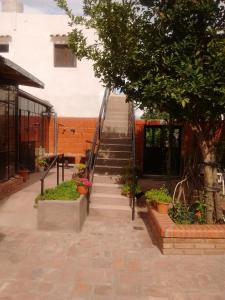 un escalier menant à un bâtiment avec un arbre dans l'établissement Hostería El Zaguan, à Cafayate