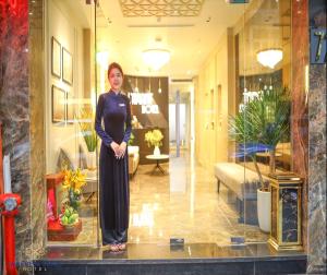 a woman is standing in a room at L'amant de Hanoi Hotel in Hanoi