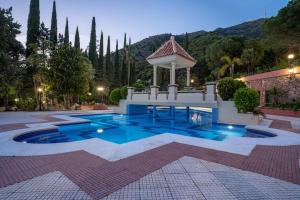a swimming pool with a gazebo in a courtyard at vituco34 in Mijas