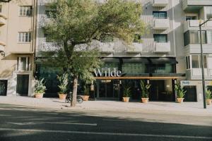 a tree in front of a white building at Wilde Aparthotels Lisbon Liberdade in Lisbon +55 photos